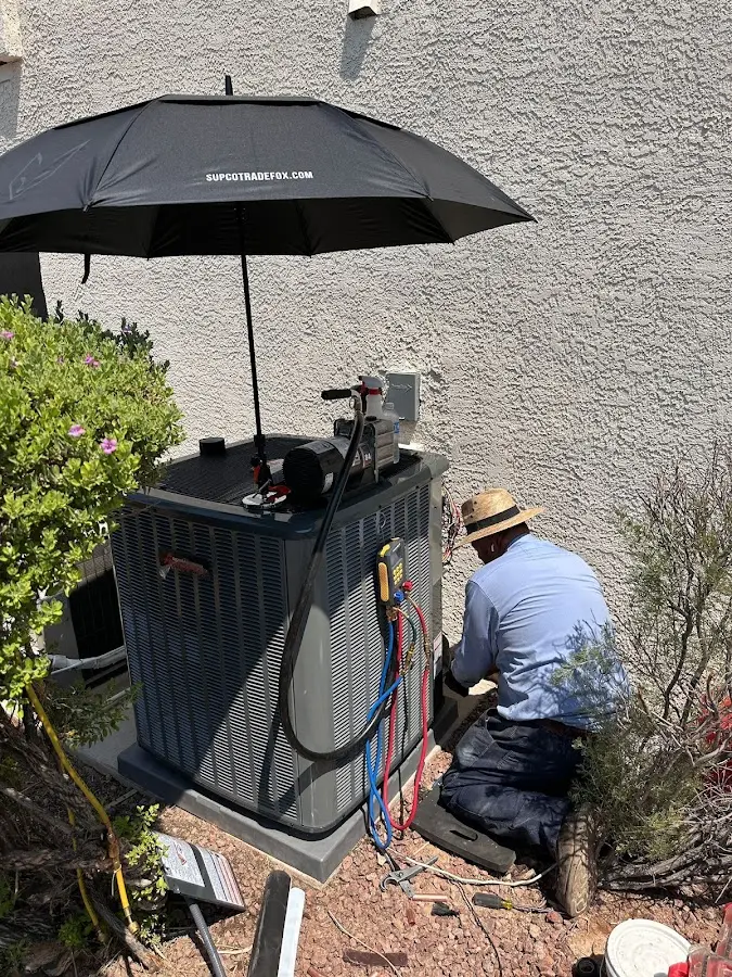 HVAC technician performing outdoor AC maintenance in East Greenbush